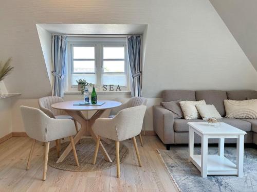 a living room with a table and a couch at Sinfonie, Whg 5 in Tinnum