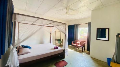 a bedroom with a bed with a canopy at Coconut Reach in Mirissa
