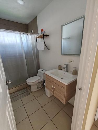 a bathroom with a toilet and a sink and a mirror at Casa Tribu in Agujas