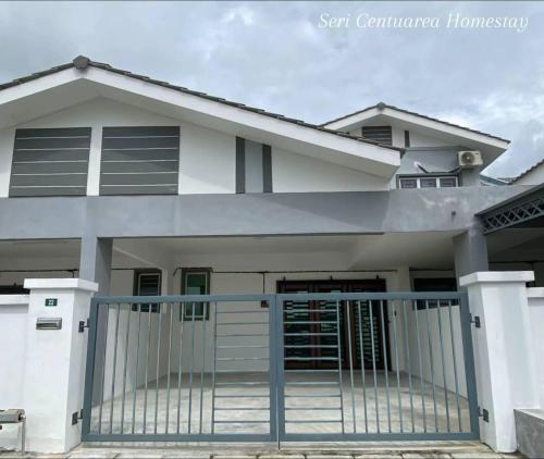a house with a gate in front of it at Seri Centuarea Homestay, Seri Iskandar in Seri Iskandar