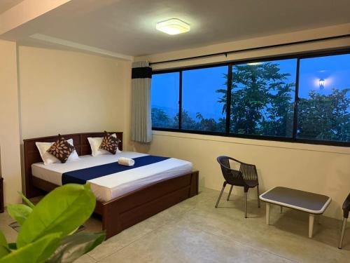 una camera da letto con un letto e una grande finestra di Mystay a Kandy