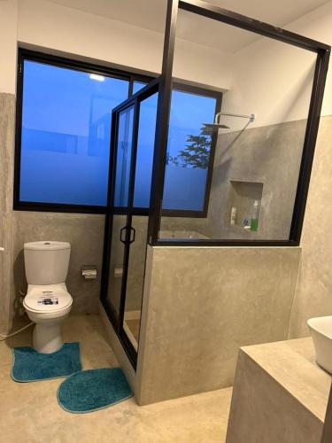 a bathroom with a toilet and a large window at Mystay in Kandy