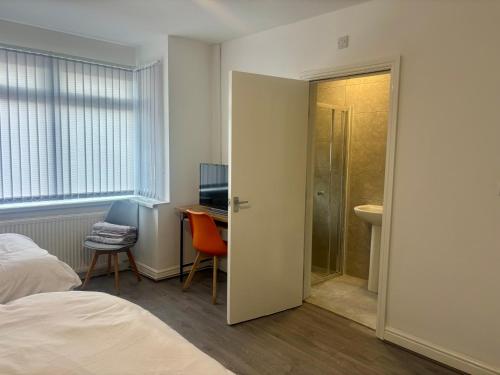 een slaapkamer met een bed en een bureau en een badkamer bij Serene Studio in Dudley in Dudley