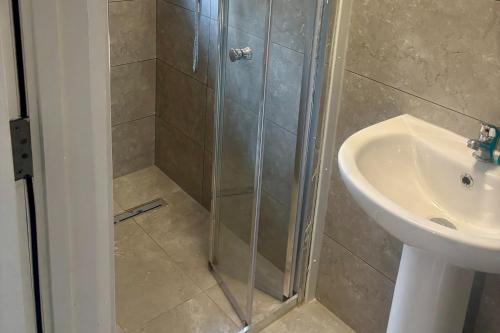 een douche met een glazen deur naast een wastafel bij Serene Studio in Dudley in Dudley