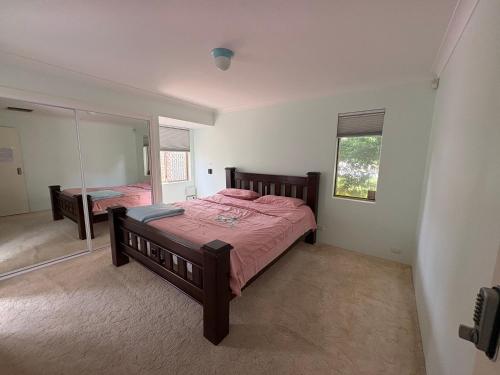 een slaapkamer met een bed en een spiegel bij Perfect home Nice location quiet holiday home with beautiful yard in Perth