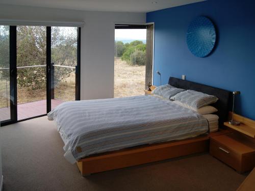 een slaapkamer met een groot bed met een blauwe muur bij Nine Mile Escape in Swansea