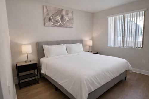ein Schlafzimmer mit einem großen weißen Bett und zwei Lampen in der Unterkunft Luxury 2 Bedrooms 2 Bathrooms With Pool and Gym in Los Angeles