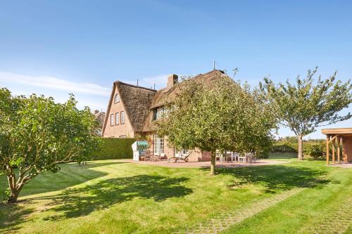 un meleto di fronte a una casa con alberi di Haus Traumstraße a Hedehusum