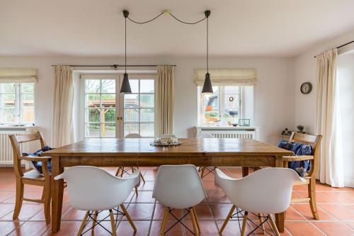 una sala da pranzo con un tavolo di legno e sedie bianche di Haus Traumstraße a Hedehusum