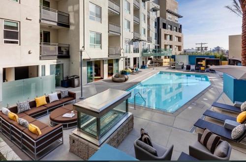 an apartment patio with a swimming pool and chairs at Luxury 2 Bedrooms 2 Bathrooms With Pool and Gym in Los Angeles