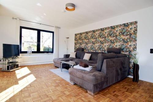a living room with a couch and a tv at Breslauer Haus in Heiligenhafen
