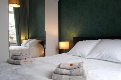 1 dormitorio con 1 cama con toallas en Maison Jamaer en Bruselas