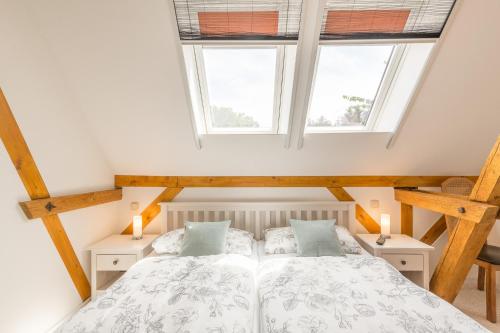 a bedroom with a bed and two windows at Ferienwohnung Ina Meta in Reppenhagen