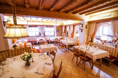 a restaurant with white tables and chairs and windows at Hotel CENTRAL Bar & Restaurant in Gerlos