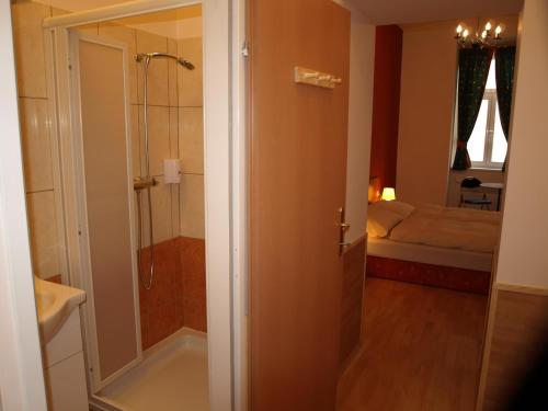 a bathroom with a shower and a bedroom at Pension Tal Studios in Vienna