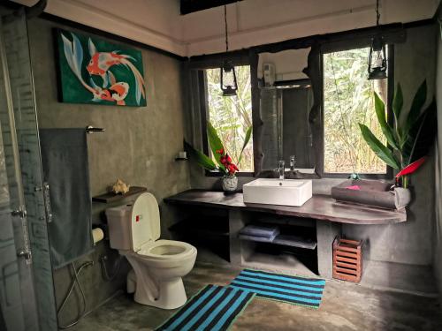 a bathroom with a toilet and a sink at The Trogon Knuckles in Rangala
