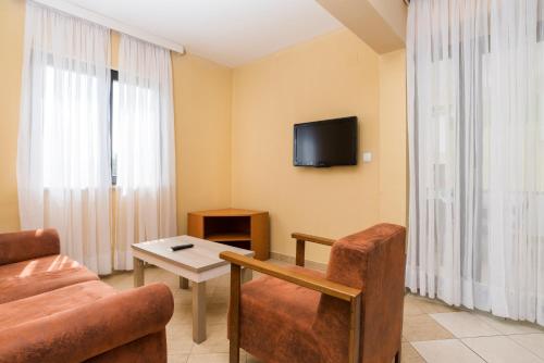 a living room with a couch and a table and a tv at Apartments Amfora Plava Laguna in Umag