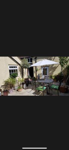 a patio with a table and an umbrella at The Old Hanging Gate Inn in Madeley