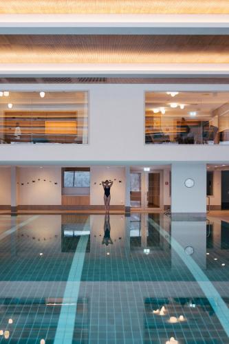 a woman is standing in a swimming pool at Suvretta House in St. Moritz