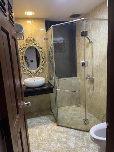 a bathroom with a sink and a shower with a mirror at MAY HOMESTAY Villa in Hue