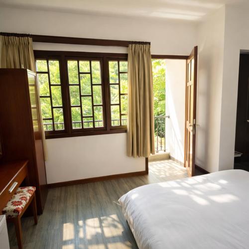 a bedroom with a bed and a large window at Tâm Tín Hotel Hồ Chí Minh in Ho Chi Minh City