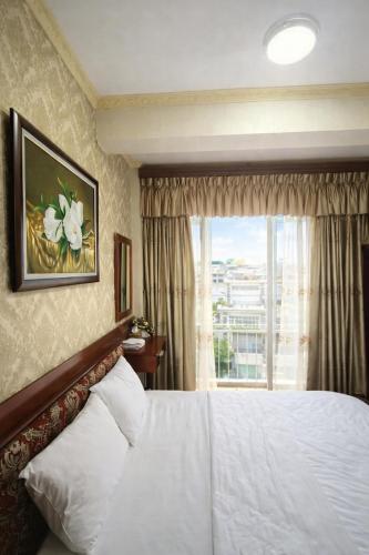 a hotel room with a bed and a window at Tâm Tín Hotel Hồ Chí Minh in Ho Chi Minh City