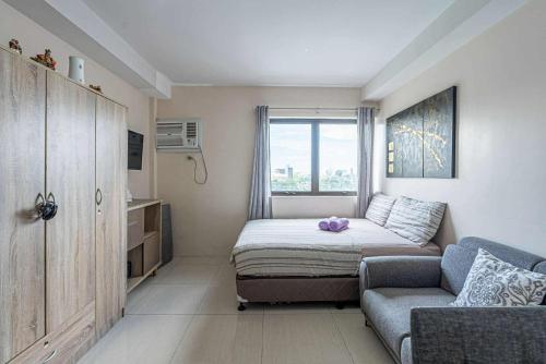 una piccola camera da letto con un letto e un divano di The Persimmon Mabolo Cebu City a Mabolo