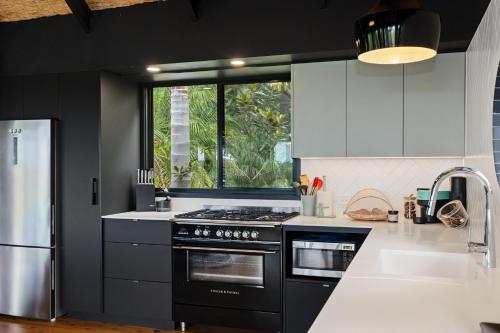 a kitchen with black and white appliances and a window at Green Buddha in Milton
