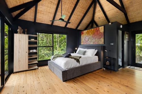 a bedroom with a large bed in a room with black walls at Green Buddha in Milton