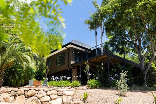 a house with a wrap around deck with trees at Green Buddha in Milton
