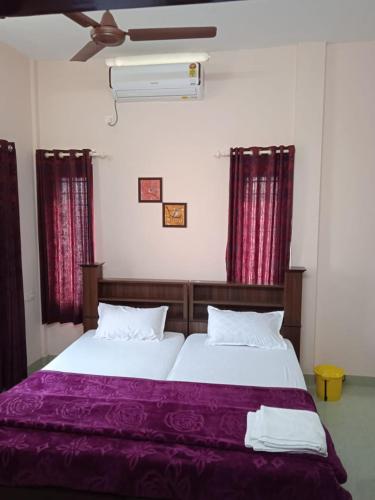 a bedroom with a large bed with purple sheets at Sakalam homestay in Trivandrum