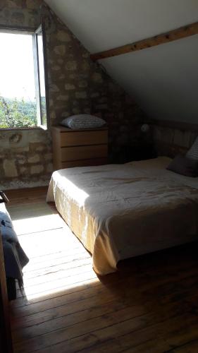 a bedroom with a bed in a room with a window at 4 Joliette in Tartiers
