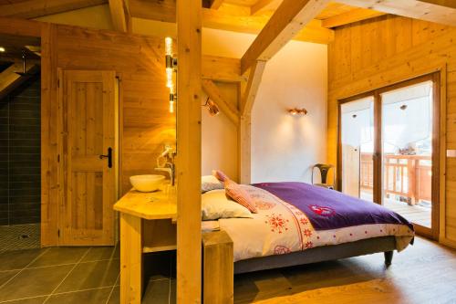a bedroom with a bed and a table in a room at Hotel Alpina in Morzine