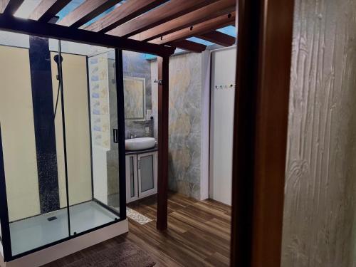 Zimmer mit einer Glastür, die zu einem Bad führt. in der Unterkunft Beny SeaBeach Residence in Belle Mare