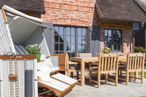 a patio with a wooden table and chairs at Hüs Amy in Rantum