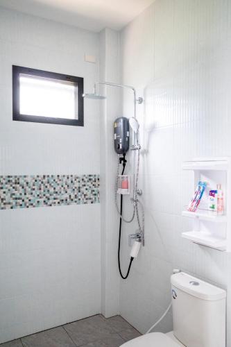 a shower in a bathroom with a toilet at The Rock Coco Villa 2 in Ban Sai Mat