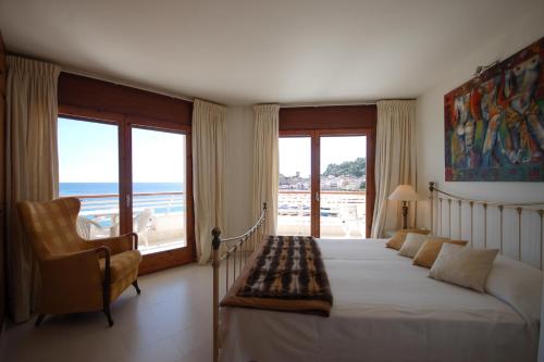 a bedroom with a bed and a view of the ocean at Lets Holidays Tossa de Mar Beach Apartment in Tossa de Mar