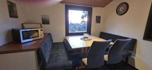 een eetkamer met een tafel met stoelen en een magnetron bij Quartier132 in Öfingen