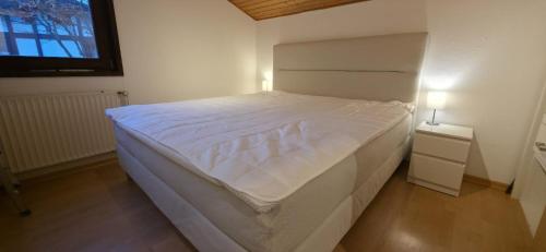 een groot wit bed in een slaapkamer met een raam bij Quartier132 in Öfingen