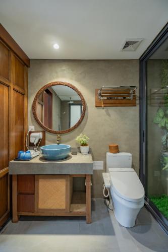 a bathroom with a sink and a toilet and a mirror at XÔI Sakamoto 2 Suites Kim Ma in Hanoi