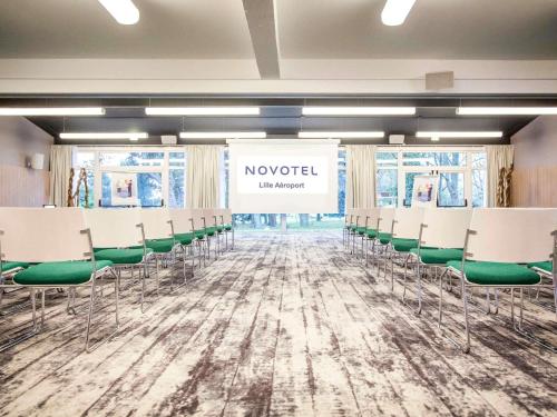 una sala conferenze con sedie e un cartello con la scritta novelsted di Novotel Lille Aéroport a Lesquin