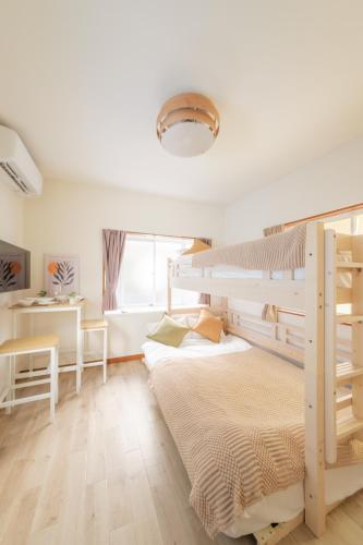 a bedroom with two bunk beds and a desk at Hotel Emile102 in Tachikawa