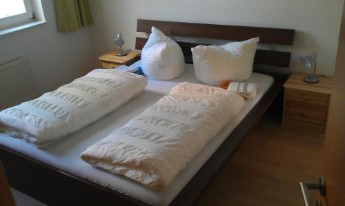 Una cama con dos almohadas blancas. en Appartements Am Theater, en Weimar