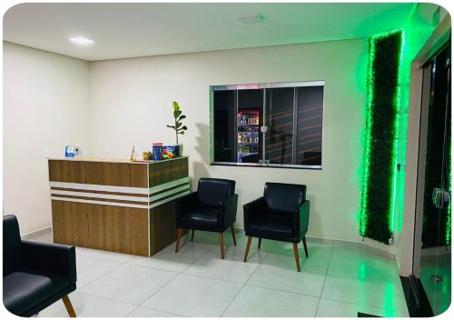 een wachtkamer met 2 stoelen en een bar bij Hotel Bueno's - Francisco Beltrão in Francisco Beltrão