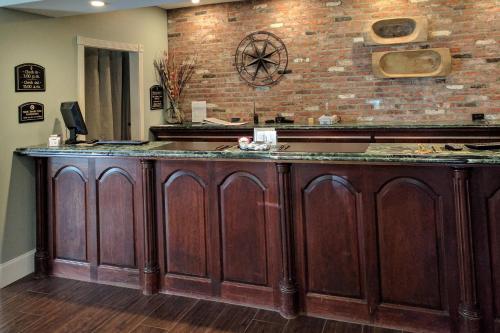 una cucina con un bancone in legno con un muro di mattoni di The Century House, an Ascend Collection Hotel a Latham