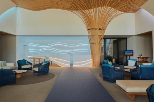 een lobby met stoelen en uitzicht op de oceaan bij Radisson Blu Aruba in Palm-Eagle Beach