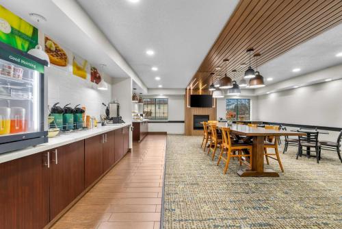 un ristorante con tavolo, sedie e cucina di Quality Inn Brewerton - Syracuse Oneida Lake Area a Brewerton