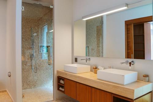 a bathroom with two sinks and a shower at Anchan Flora Luxury 2BR Pool Villa in Thalang