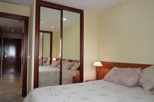1 dormitorio con 2 camas y un espejo grande en La Nogalera 7, en Torremolinos