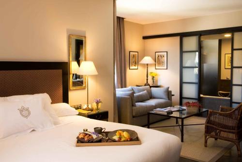 a hotel room with a bed and a living room at Asia Gardens Hotel & Thai Spa, a Royal Hideaway Hotel in Finestrat